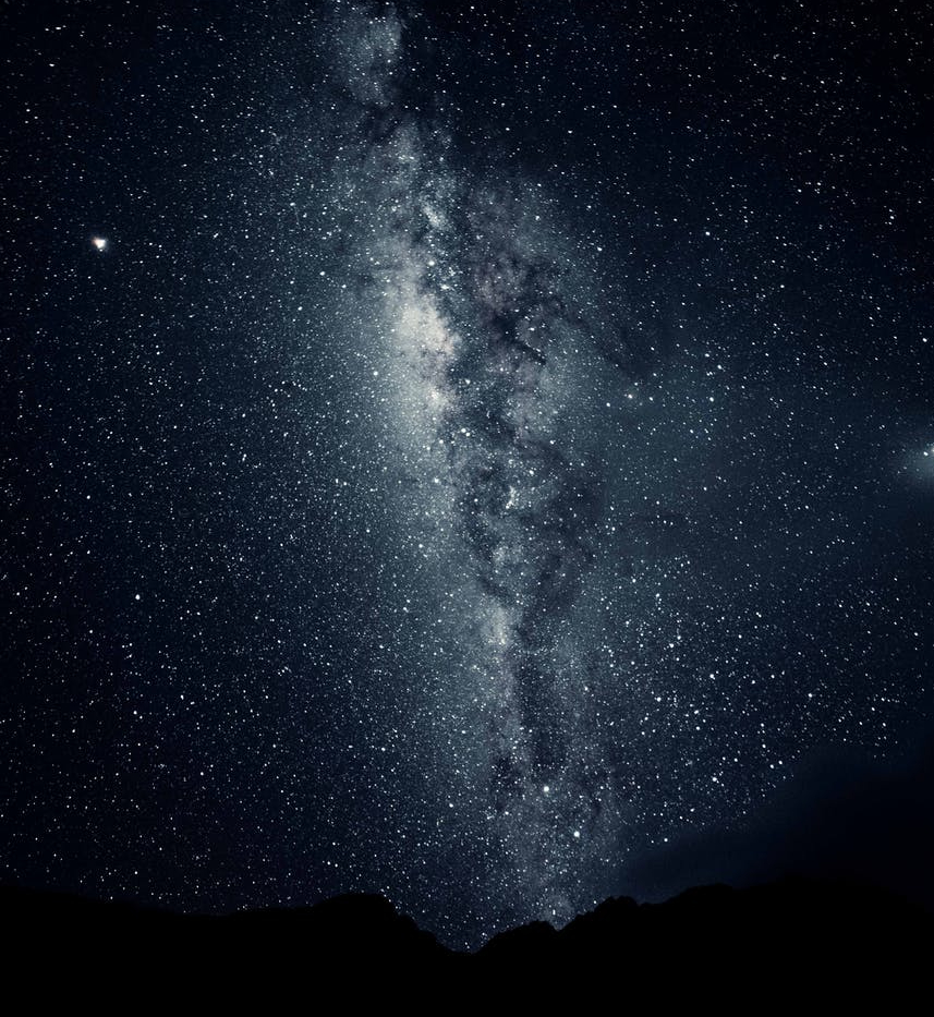 silhouette of mountain under starry night